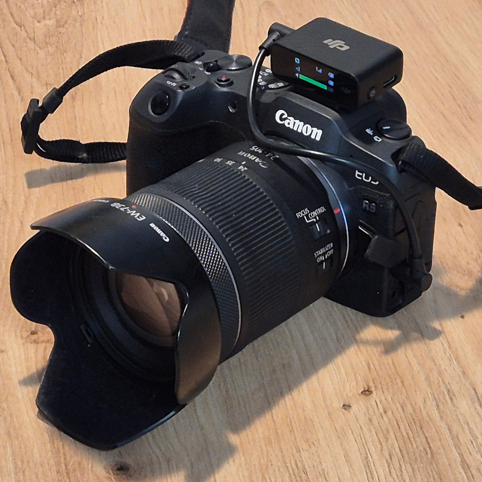 Přijímač DJI Mic první generace na fotoaparátu Canon propojený úhlovým audio kabelem.